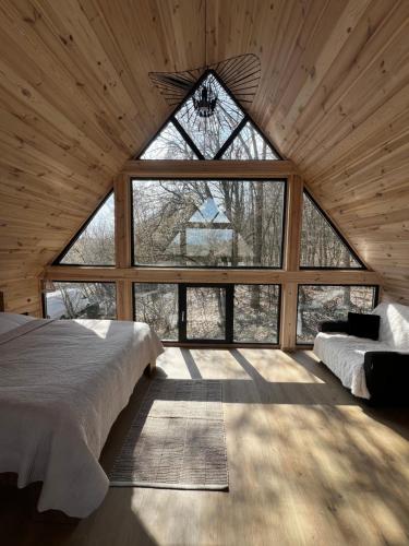 a room with two beds and a large window at Tysha House in Ternopil