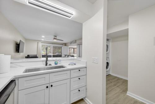 a white kitchen with a sink and a washing machine at Indoor/Outdoor Pools!! Hot Tub! Steam Room! Sauna! in Osage Beach