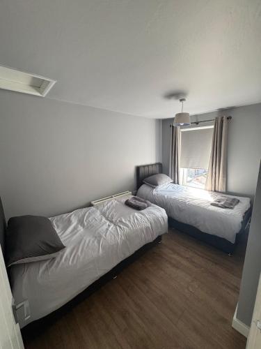 a bedroom with two beds and a window at Serene escape in Cleator Moor