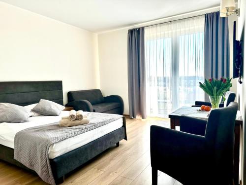 a bedroom with a bed and a table and chairs at Jerry Apartment in Jastrzębia Góra