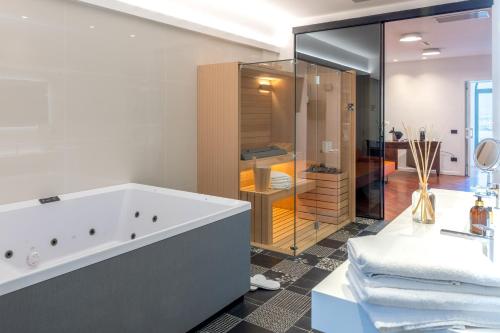 a bathroom with a tub and a glass shower at Relais Villa Flora Berta in Matelica