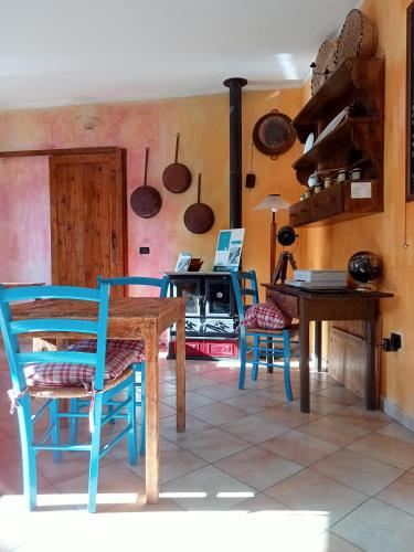 a dining room with a table and chairs and a stove at Locanda D'Ogliastra in Triei