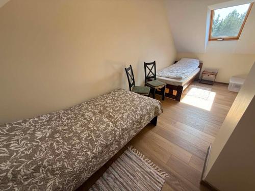 a small room with two beds and a window at Leśna przystań in Trupel