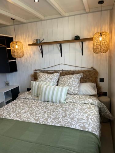 a bedroom with a bed with pillows and two lights at Retour de Plage in Saint-Pair-sur-Mer