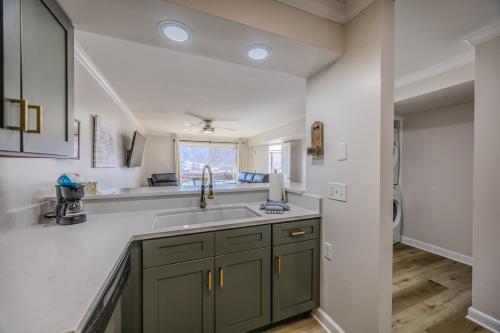 a kitchen with green cabinets and a sink at 22 Mile Marker! Indoor/Outdoor Pools, Hot Tub! New in Osage Beach