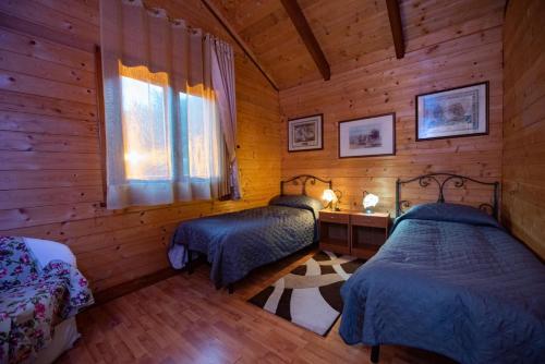 a bedroom with two beds in a log cabin at Il Borgo sul Lago in Pizzo