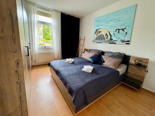 a bedroom with a bed with two towels on it at Villa Iduna mit modern desingten Apartments in Graal-Müritz