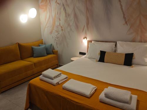 a bedroom with a large bed and a couch at Aggeliki Apartment in Skiathos