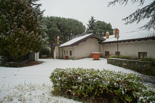 a house with snow on the ground next to a driveway at Etna Paradise locazioni brevi in Ragalna