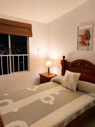 a bedroom with a bed and a window at Espectacular! Apartamento en cali cerca al coliseo del pueblo in Cali