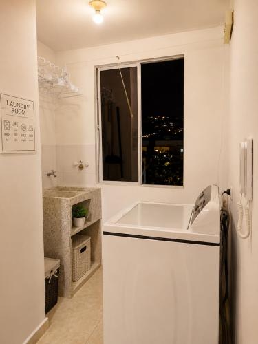 a white bathroom with a sink and a window at Espectacular! Apartamento en cali cerca al coliseo del pueblo in Cali
