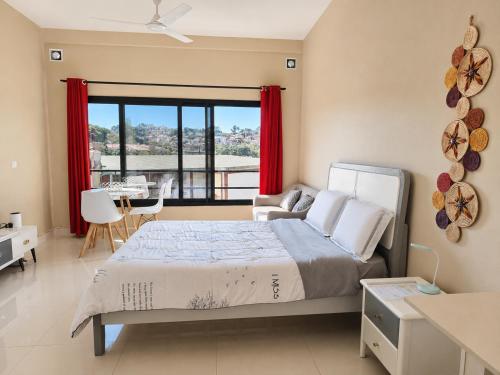 a bedroom with a large bed with red curtains at Milestone City Business Apartment - Secure Area - Fast WiFi Long Stay in Antananarivo