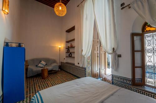 a bedroom with two beds and a window at Riad Lik in Fez