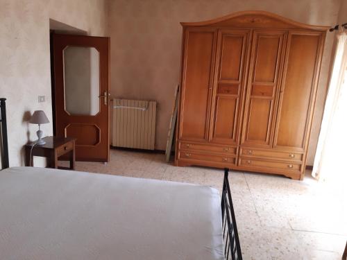 a bedroom with a large wooden cabinet and a mirror at la casa nell'acropoli , piano terra in Arpino