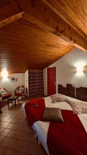 a large bed in a room with a wooden ceiling at CHAMBRES D'HOTES L'ANTONIN in Saint-Antoine
