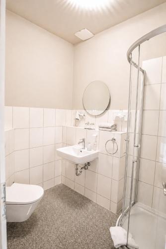 a bathroom with a toilet and a sink and a shower at Hotel Schloss Teutschenthal in Teutschenthal