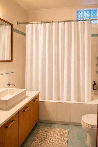 a bathroom with a toilet sink and a shower curtain at Niobe Luxury Residence in Loutraki