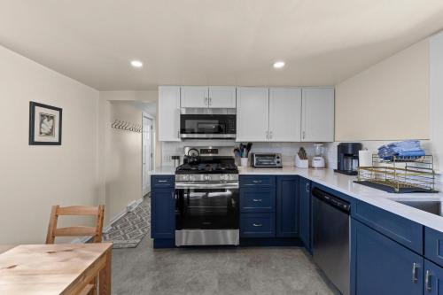 a kitchen with blue cabinets and a stove top oven at The Longfellow Bungalow in Minneapolis