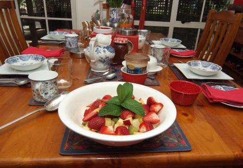 a wooden table with a bowl of fruit on it at The Loft Bed and Breakfast in Taupo