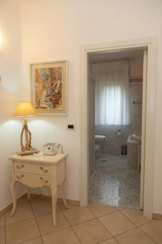 a room with a table with a lamp and a bathroom at Natura e Relax Casa Emma in Buonvicino