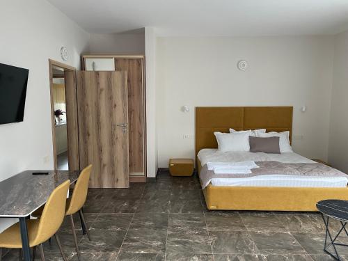 a bedroom with a bed and a table and chairs at Hiking&Ski Hotel in Bukovel