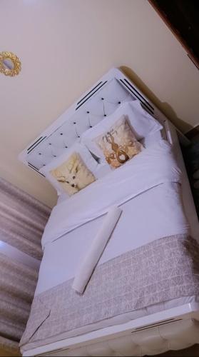 a bed with white sheets and teddy bears on it at Cozy cloud in Ruiru