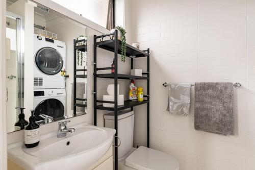 a bathroom with a sink and a washing machine at Richmond apartment close to MCG in Melbourne