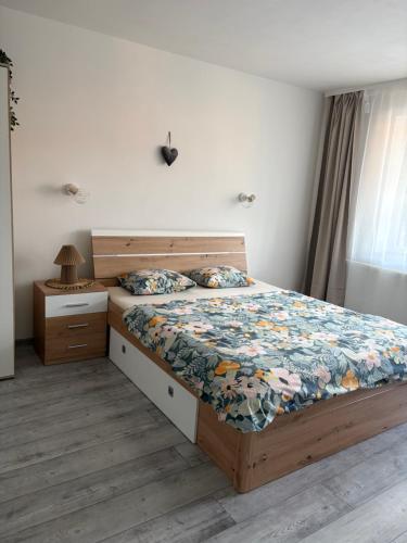 a bedroom with a bed with a wooden bed frame and a night stand at Apartmán Olive in Terchová