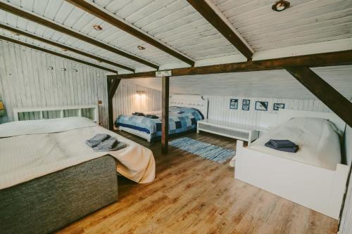 a bedroom with two beds and a couch in it at Beachside Guest House Piejuras nams in Ķesterciems