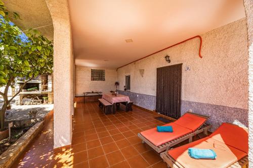 a room with chairs and tables on a patio at Pool Apartments Franko - Shared Pool in Ližnjan