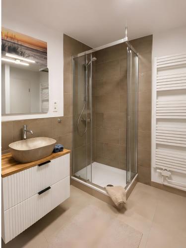 a bathroom with a sink and a shower at Gaestehaus Nuke in Langeneß