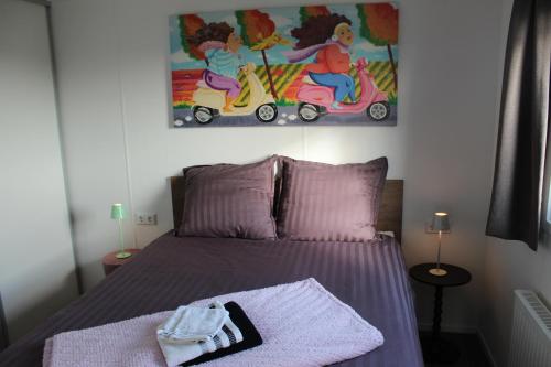 a bedroom with a bed and a painting on the wall at Chalet vrijheid in Tjerkgaast