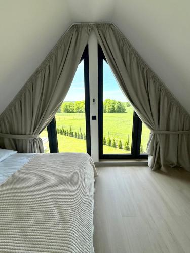 a bedroom with a bed and a large window at Stodoły pod Łysą Górą in Huta Szklana