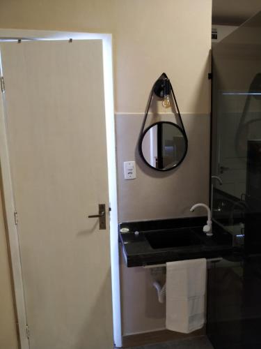 a bathroom with a sink and a mirror at Loft Campinho 3 in Estação Inhoaíba