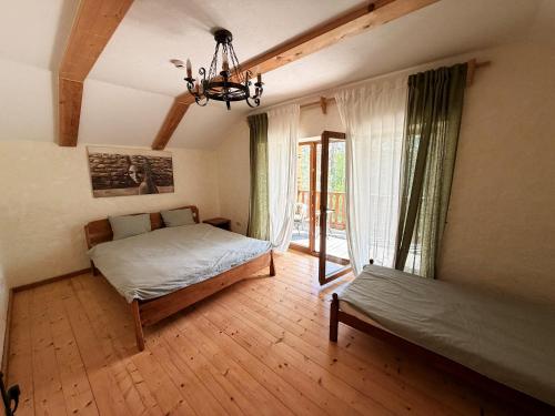 a bedroom with a bed and a chandelier at Brižių sodyba in Brižiai