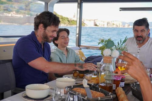 a group of people sitting around a table with food at Aquaïa, Saint-Tropez by sea in Cogolin
