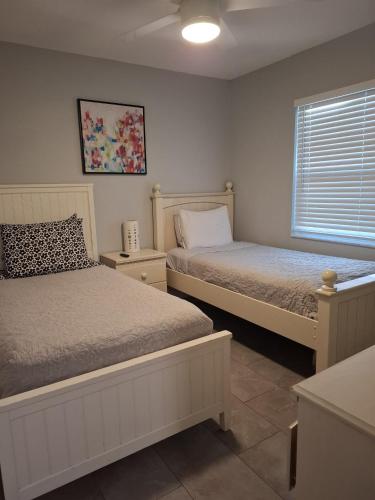 a bedroom with two beds and a window at Home Away from Home with Heated Pool in New Port Richey