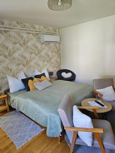 a bedroom with a bed and a couch and a table at Ágnes Apartmanok in Harkány
