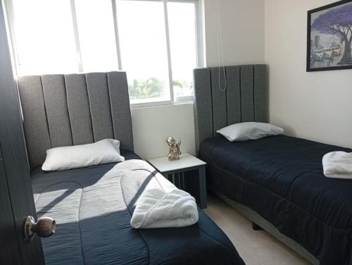a bedroom with two beds and two windows at Habibi Cocoyoc in Cocoyoc