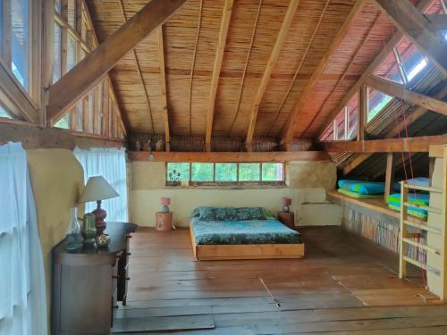 a bedroom with a bed in a room with wooden ceilings at Chalet Casa de Teja in Tinjacá