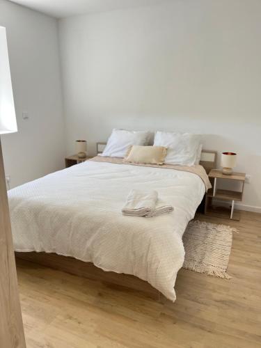 a bedroom with a bed with two towels on it at Cosy Appartement avec Parking in Feugarolles