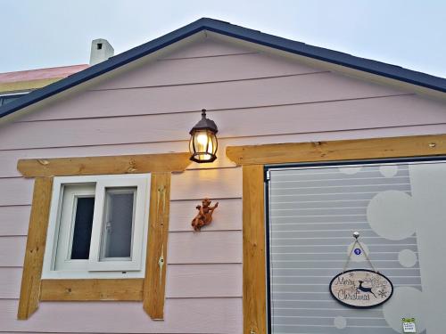 a light on the side of a house with a garage at Yours Guesthouse in Tongyeong in Tongyeong