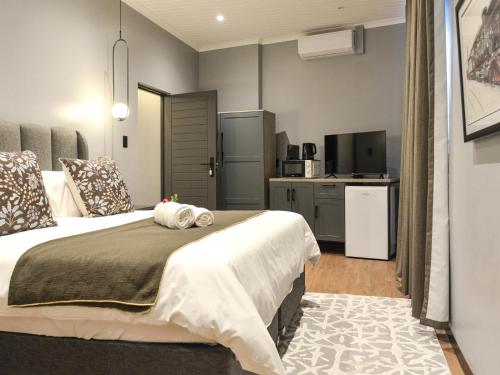 a bedroom with a large bed and a kitchen at The Siding Apartments in Hilton
