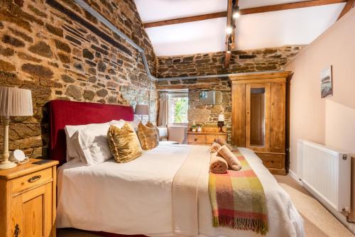 a bedroom with a bed and a stone wall at Shippon in Michaelstow