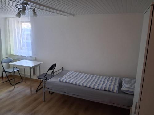 a bedroom with a bed and a table and a desk at Gemütliche Monteurunterkunft bei Lübeck in Stockelsdorf