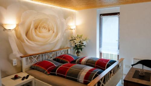 a bedroom with a bed with a flower on the wall at Hotel Garni Silberburg - Schwarzwald-Plus Karte in Bad Wildbad