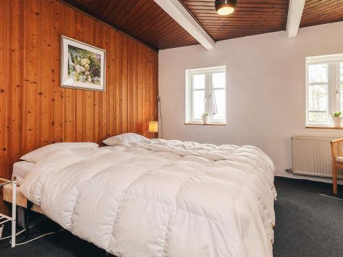 a large bed in a bedroom with wooden walls at 4 star holiday home in Aabybro in Åbybro