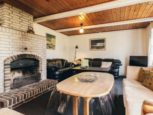 a living room with leather furniture and a fireplace at 4 star holiday home in Aabybro in Åbybro