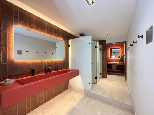 a bathroom with a red sink and a mirror at Sereno Hostels in Bogotá
