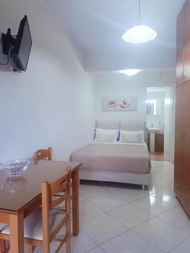 a bedroom with a bed and a table and a desk at Georgias House in Lefkada